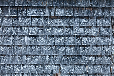 Cedar shingles on a cold day with a coating of snow on them.